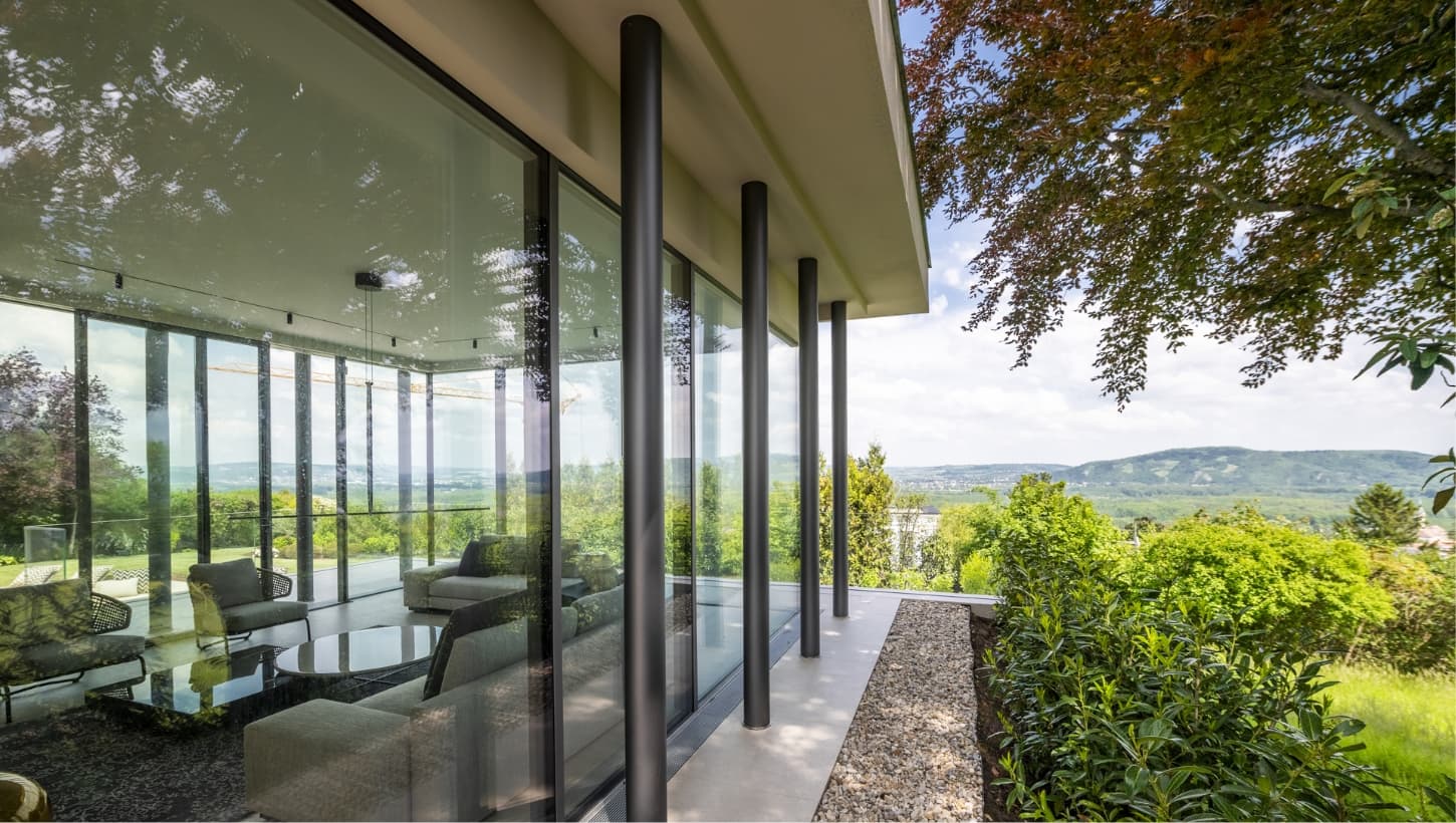 Villa mit Glasfront und Blick in die Landschaft